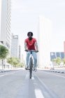 Вид сбоку на велосипед афроамериканского велосипедиста на солнечной набережной — стоковое фото