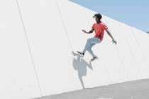 Low angle of active hipster black male jumping on ramp in skate park — Stock Photo