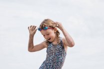 Mädchen mit Brille beim Tanzen und Spaß am Strand im Sommer — Stockfoto