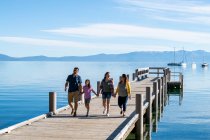 A family walks on a pier on a calm beautiful day in South Lake Tahoe, California. — Stock Photo