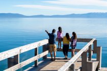 Родина дивиться на спокійні води озера Тахо з пірса в сонячний літній день у Південному озері Тахо (штат Каліфорнія).. — стокове фото