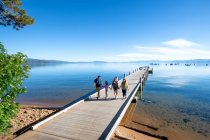 Eine Familie spaziert an einem ruhigen, schönen Tag auf einem Steg im South Lake Tahoe, Kalifornien. — Stockfoto