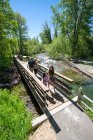 Une famille traverse un pont au-dessus du ruisseau Taylor lors d'une journée d'été à South Lake Tahoe, Californie. — Photo de stock