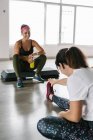 Reife Frau beim Stretching im Fitnessstudio mit ihrem Personal Trainer — Stockfoto