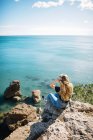 Сидить біля бірюзового моря — стокове фото