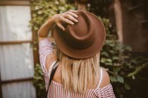 Schöne junge Frau mit Hut im Garten — Stockfoto