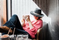 Mulher pensando enquanto bebe uma bebida quente em um café no outono — Fotografia de Stock