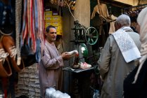 Uomo egiziano che vende scarpe in un mercato all'aperto — Foto stock