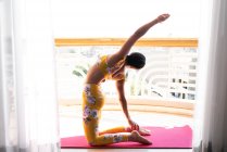 Mujer hace yoga fuera en cubierta - foto de stock