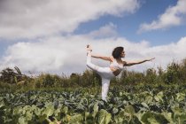 Yogi féminin dans la pose de l'enfant dans un champ de légumes verts — Photo de stock