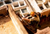 Moroccan man climbing ladder in Fez Tannery — Stock Photo
