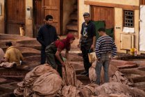 Grupo de trabajadores masculinos del cuero en curtiduría en fez, Marruecos - foto de stock