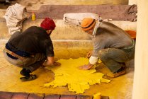 Men dying leather hide yellow in fez tannery in Morocco — Stock Photo