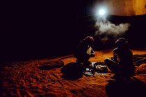 Zwei Beduinen bereiten im jordanischen Wadi Rum eine traditionelle gekochte Mahlzeit zu — Stockfoto