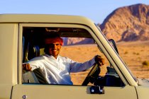 Um beduíno posa em seu caminhão em Wadi Rum, Jordânia — Fotografia de Stock