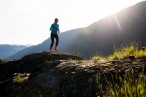 Спортсменка бегает по камням в горах — стоковое фото