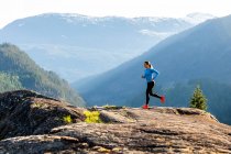 Sportswoman courir sur des pierres dans les hauts plateaux — Photo de stock
