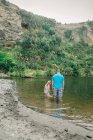 Отец и дочь играют в воде в живописном месте на реке — стоковое фото