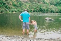 Padre e figlia in un punto panoramico del fiume che giocano in acqua — Foto stock