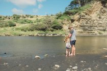 Father and daughter fishing at a scenic river spot — Stock Photo