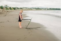 Jovem de pé na praia com seu skim board — Fotografia de Stock
