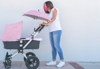 Mutter geht mit ihrem Baby im Einkaufswagen — Stockfoto