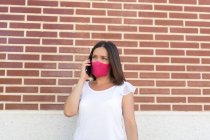 Beautiful woman with mask talking on her smartphone — Stock Photo