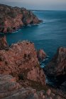 Beautiful view of a cliff in the bay of the mediterranean sea in the distance, the sun sets of — Stock Photo