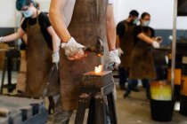 Fabbri raccolto colpire dettaglio metallo caldo con martello durante la forgiatura — Foto stock