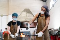 Lavoratori di sesso maschile che forgiano ferro in officina — Foto stock