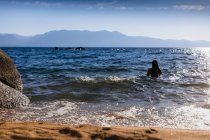 Mujer joven de pie en el mar - foto de stock