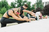 Group of people stretching outdoors after training — Stock Photo