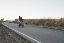 Couple riding a motorcycle on the road — Stock Photo