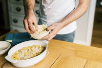 A father putting streusel on a peach cobbler — Stock Photo