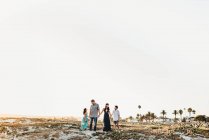Bonne famille tenant la main debout sur la plage — Photo de stock