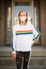 Menina soprando bolhas em uma camisa do arco-íris — Fotografia de Stock