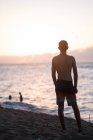 Хлопчик-підліток спостерігає за заходом сонця на північному березі Оаху — стокове фото