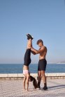 L'uomo e la giovane donna atleti fanno equilibri — Foto stock
