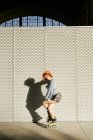 Menina ruiva alternativa nova com patins em uma parede de metal — Fotografia de Stock