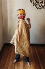School aged young boy in dressed as king with face mask — Stock Photo
