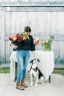 Femme propriétaire d'entreprise et agriculteur de fleurs avec son chien — Photo de stock