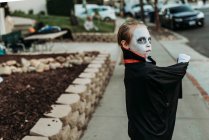 Мальчик школьного возраста в костюме Дракулы позирует в Хэллоуин — стоковое фото