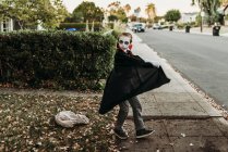 Niño de edad escolar vestido como Drácula posando disfrazado en Halloween - foto de stock