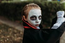 Niño de edad escolar vestido como Drácula posando disfrazado en Halloween - foto de stock