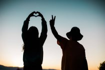 Love and Peace Sign Silhouettes with Colorful Sky - Young People — Stock Photo