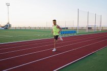 Junger Mann trainiert Laufen auf neuen und roten Gleisen — Stockfoto