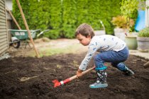 Маленький мальчик помогает родителям с проектом на заднем дворе — стоковое фото