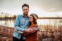 Glückliches Paar, das sich an einem Herbstabend an einem See in Denver CO umarmt — Stockfoto