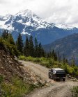 Conducción de coches a lo largo de carretera rural en montañas - foto de stock