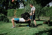 Two men working out together at home in the garden gym — Stock Photo